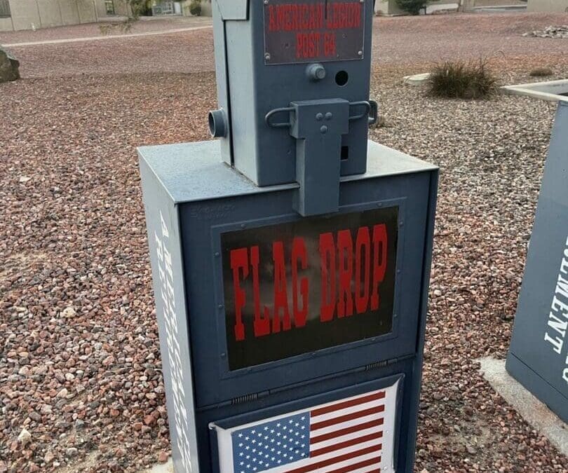 A Post 64 flag-retirement drop-off box outside a community building.